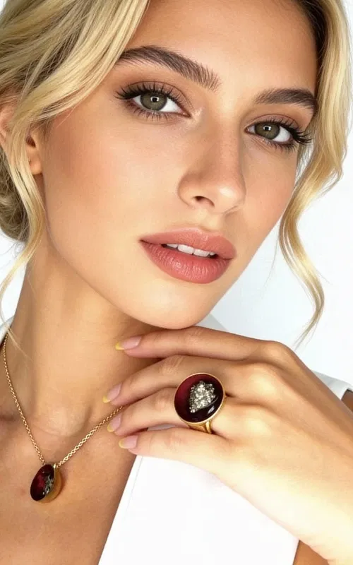 Ανακαλύψτε τη μαγεία του χειροποίητου κοσμήματος με αυτό το εντυπωσιακό γυναικείο δαχτυλίδι με πυρίτη σε μπορντό απόχρωση. Σχεδιασμένο από την Ελληνίδα Σχεδιάστρια Κοσμημάτων Αικατερίνη Χαλκιαδάκη, το δαχτυλίδι αυτό συνδυάζει την παραδοσιακή ελληνική τεχνοτροπία με τη σύγχρονη αισθητική.
Το μεγάλο δαχτυλίδι διαθέτει στρογγυλή επιφάνεια σε έντονο μπορντό χρώμα, στο κέντρο της οποίας λάμπει φυσικός σιδηροπυρίτης με το χαρακτηριστικό του χρυσαφί μεταλλικό γυαλάδι. Η βάση από ορείχαλκο προσφέρει σταθερότητα και άνεση στη φορεσιά, ενώ η χειροποίητη κατασκευή εγγυάται τη μοναδικότητα κάθε κομματιού.
Αυτό το statement δαχτυλίδι είναι ιδανικό για να συμπληρώσει τόσο καθημερινά όσο και βραδινά σύνολα, προσδίδοντας μια πινελιά αυθεντικής ελληνικής τέχνης στο στυλ σας. Φυλάσσετε σε στεγνό μέρος και καθαρίζετε με μαλακό πανί για να διατηρήσετε τη λάμψη του κοσμήματος.