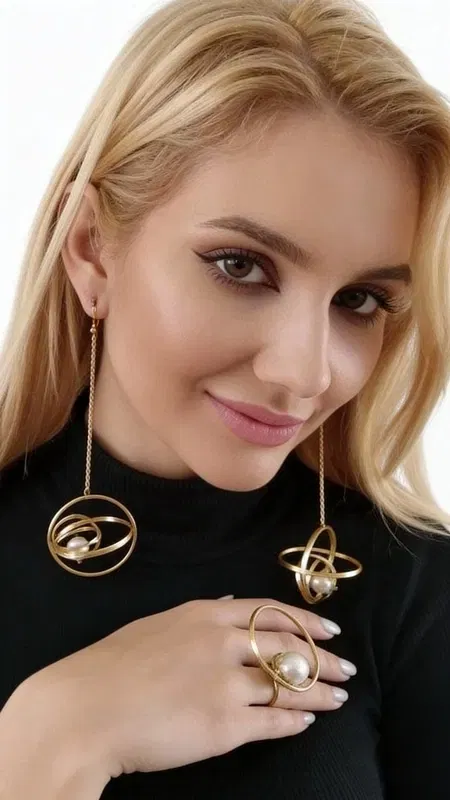 , Εντυπωσιακά μακριά σκουλαρίκια με πέρλες που συνδυάζουν τη σύγχρονη αισθητική με τη διαχρονική κομψότητα. Αυτά τα statement κρεμαστά σκουλαρίκια παρουσιάζουν έναν μοναδικό σχεδιασμό με χρυσούς κρίκους και λευκές πέρλες, δημιουργώντας μια εντυπωσιακή σύνθεση που τραβά τα βλέμματα.
Τα σκουλαρίκια διαθέτουν δύο χρυσούς κρίκους σε διαφορετικά μεγέθη, με τον εσωτερικό να φιλοξενεί μια πέρλα που κρέμεται κομψά. Η ιδιαίτερη κατασκευή τους επιτρέπει την κίνηση, δίνοντας έναν δυναμικό χαρακτήρα στο κόσμημα. Σχεδιασμένα από την Ελληνίδα Σχεδιάστρια Κοσμημάτων Αικατερίνη Χαλκιαδάκη, αυτά τα χειροποίητα σκουλαρίκια αποτελούν την τέλεια επιλογή για σύγχρονες γυναίκες που αναζητούν μοντέρνα κοσμήματα με χαρακτήρα.
Ιδανικά για ιδιαίτερες στιγμές, νυφικές εμφανίσεις ή καθημερινές εξόδους όπου θέλετε να ξεχωρίσετε. Το χρυσό χρώμα συνδυάζεται εύκολα με κάθε ντύσιμο, ενώ οι πέρλες προσθέτουν μια νότα κομψότητας και φινέτσας. Αποθηκεύστε σε στεγνό μέρος και καθαρίζετε με μαλακό πανί.