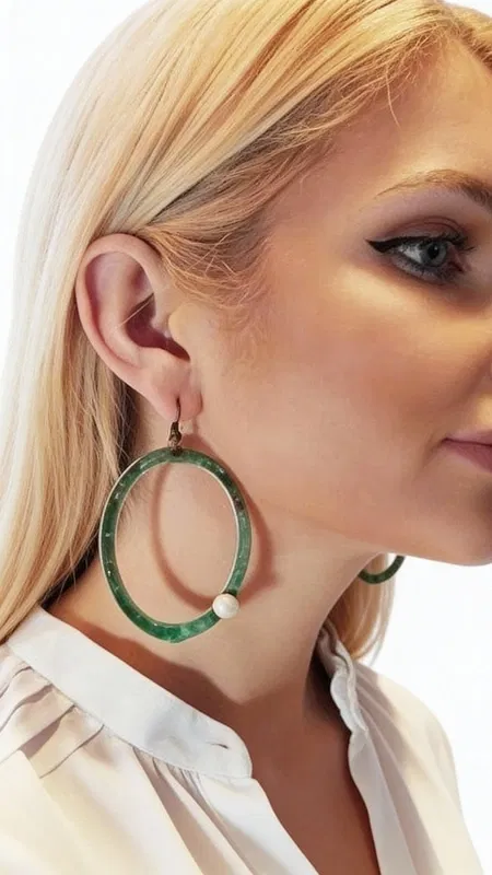 , Εντυπωσιακά κρεμαστά σκουλαρίκια κρίκοι με μαργαριτάρια που συνδυάζουν τη φυσική ομορφιά των πέρλων με την αυθεντική ελληνική τέχνη. Σχεδιασμένα από την Ελληνίδα Σχεδιάστρια Κοσμημάτων Αικατερίνη Χαλκιαδάκη, αυτά τα μοναδικά χειροποίητα σκουλαρίκια αποτελούν την τέλεια επιλογή για τη γυναίκα που αναζητά πρωτότυπα κοσμήματα με χαρακτήρα.
Η πράσινη πατίνα που καλύπτει το χαλκό δημιουργεί μια vintage αισθητική που ταιριάζει τόσο σε καθημερινά όσο και σε επίσημα look. Οι λευκές πέρλες προσθέτουν κομψότητα και φωτεινότητα, δημιουργώντας έναν τέλειο συνδυασμό που τονίζει τη φυσική ομορφιά του προσώπου. Η ιδιαίτερη επεξεργασία του χαλκού δίνει σε κάθε κόσμημα μοναδικό χαρακτήρα.
Αυτά τα μοντέρνα κρεμαστά σκουλαρίκια είναι ιδανικά για γάμο, βραδινές εξόδους ή όταν θέλετε να προσθέσετε μια δόση bohemian κομψότητας στην καθημερινότητά σας. Φυλάξτε σε στεγνό μέρος και καθαρίστε απαλά με μαλακό πανί για να διατηρήσετε τη λάμψη των μαργαριταριών και την πατίνα του χαλκού.