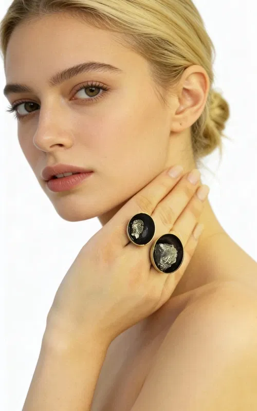 Ανακαλύψτε την τέλεια ισορροπία μεταξύ δύναμης και κομψότητας με αυτό το μεγάλο εντυπωσιακό γυναικείο δαχτυλίδι με διπλό πυρίτη, σχεδιασμένο από την Αικατερίνη Χαλκιαδάκη. Το μοναδικό χειροποίητο δαχτυλίδι συνδυάζει δύο φυσικούς κρυστάλλους σιδηροπυρίτη σε μια εκπληκτική σύνθεση που κεντρίζει τα βλέμματα.
Η μαύρη πατίνα δημιουργεί εντυπωσιακή αντίθεση με τα χρυσαφί κρύσταλλα του πυρίτη, ενώ ο ορείχαλκος προσδίδει θερμότητα και διαρκότητα στο κόσμημα. Η ανοιχτή δομή του δαχτυλιδιού επιτρέπει την άνετη εφαρμογή σε διάφορα μεγέθη δακτύλου, ενώ οι δύο ωοειδείς πέτρες πυρίτη σε διαφορετικά μεγέθη δημιουργούν δυναμική σύνθεση.
Ο σιδηροπυρίτης θεωρείται πέτρα προστασίας και δύναμης, ιδανική για γυναίκες που θέλουν να εκφράσουν την προσωπικότητά τους με στυλ. Το statement δαχτυλίδι συνδυάζεται τέλεια με casual και επίσημα outfits, προσδίδοντας μοναδικό χαρακτήρα σε κάθε εμφάνιση.