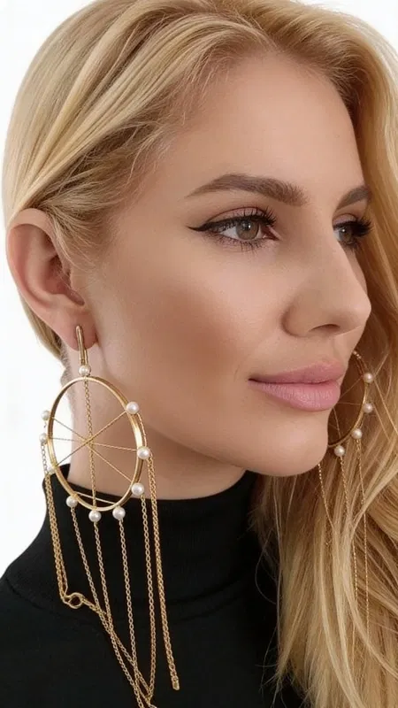 , Ανακαλύψτε τη μαγεία των μεγάλων εντυπωσιακών σκουλαρικιών κρεμαστών με πέρλες που θα μεταμορφώσουν κάθε σας εμφάνιση. Αυτά τα μοναδικά χειροποίητα σκουλαρίκια "Ονειροπαγίδα", σχεδιασμένα από την Ελληνίδα Σχεδιάστρια Κοσμημάτων Αικατερίνη Χαλκιαδάκη, συνδυάζουν τη σύγχρονη αισθητική με την παραδοσιακή ελληνική τεχνοτροπία.
Κατασκευασμένα από υψηλής ποιότητας ορείχαλκο με χρυσή απόχρωση, τα σκουλαρίκια διαθέτουν γεωμετρικό σχέδιο κύκλων που στολίζονται με φυσικές πέρλες. Οι κρεμαστές αλυσίδες δημιουργούν μια κομψή κίνηση που προσελκύει τα βλέμματα, ενώ το statement design τους τα καθιστά ιδανικά για ιδιαίτερες στιγμές.
Τα μακριά σκουλαρίκια συνδυάζονται τέλεια με βραδινά σύνολα, νυφικές εμφανίσεις ή boho chic looks, προσφέροντας μια πινελιά πολυτέλειας και μυστηρίου. Η εργονομική τους κατασκευή εξασφαλίζει άνεση όλη μέρα.