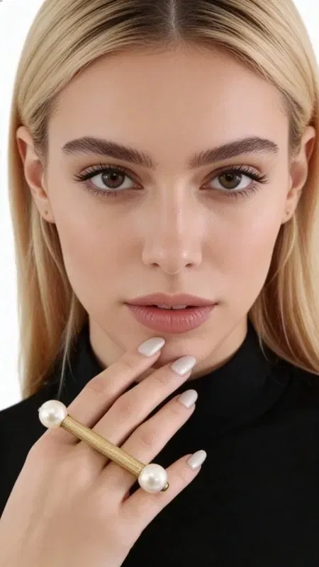 , Ανακαλύψτε την τέλεια ισορροπία μεταξύ σύγχρονου design και κλασικής κομψότητας με αυτό το εντυπωσιακό statement δαχτυλίδι με πέρλα. Σχεδιασμένο από την Ελληνίδα Σχεδιάστρια Κοσμημάτων Αικατερίνη Χαλκιαδάκη, το χειροποίητο δαχτυλίδι συνδυάζει τη μοντέρνα αισθητική με τη διαχρονική γοητεία της πέρλας.
Το μοναδικό γεωμετρικό σχήμα του δαχτυλιδιού σε χρυσή απόχρωση δημιουργεί μια εκλεπτυσμένη βάση για τις δύο φυσικές πέρλες που κοσμούν τα άκρα. Η ανοιχτή κατασκευή προσφέρει ευελιξία στη φορεσιά, ενώ ο μοντέρνος σχεδιασμός το καθιστά ιδανικό για casual αλλά και πιο επίσημες εμφανίσεις.
Αυτό το γυναικείο δαχτυλίδι με πέρλα αποτελεί την τέλεια επιλογή για όσες αναζητούν χειροποίητα κοσμήματα που ξεχωρίζουν. Η ποιότητα της ελληνικής χειροτεχνίας φαίνεται σε κάθε λεπτομέρεια, από την επεξεργασία του μετάλλου μέχρι την τοποθέτηση των πέρλων. Αποθηκεύετε σε στεγνό μέρος και καθαρίζετε απαλά με μαλακό πανί για να διατηρήσετε τη λάμψη των πέρλων και του μετάλλου.