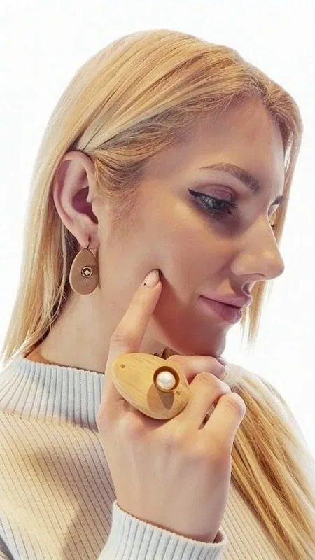 , Ανακαλύψτε τη φυσική κομψότητα με αυτά τα μοναδικά κρεμαστά σκουλαρίκια που συνδυάζουν ξύλο και μαργαριτάρια σε έναν υπέροχο σχεδιασμό. Σχεδιασμένα από την Ελληνίδα Σχεδιάστρια Κοσμημάτων Αικατερίνη Χαλκιαδάκη, αυτά τα χειροποίητα κοσμήματα προσφέρουν μια σύγχρονη ματιά στην κλασική κομψότητα.
Κάθε σκουλαρίκι χαρακτηρίζεται από μια οβάλ ξύλινη βάση σε φυσικό καφέ χρώμα που συμπληρώνεται από ένα τετράγωνο μεταλλικό στοιχείο με λευκή πέρλα στο κέντρο. Ο συνδυασμός αυτός δημιουργεί μια υπέροχη αντίθεση υφών και χρωμάτων που προσελκύει το βλέμμα. Η φυσική ζεστασιά του ξύλου αρμονίζει τέλεια με τη λάμψη των μαργαριταριών, δημιουργώντας ένα κόσμημα που είναι ιδανικό τόσο για καθημερινή όσο και για ειδική εμφάνιση.