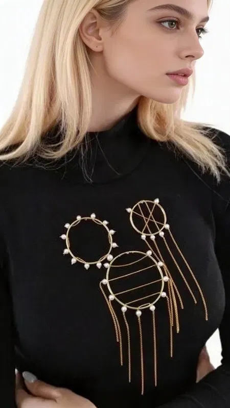 Ανανεώστε την εμφάνισή σας με αυτό το εντυπωσιακό statement σετ 3 καρφιτσών με πέρλες, ένα μοναδικό κόσμημα που συνδυάζει μοντέρνο design με κλασική κομψότητα. Σχεδιασμένο από την Ελληνίδα Σχεδιάστρια Κοσμημάτων Αικατερίνη Χαλκιαδάκη, αυτό το χειροποίητο σετ περιλαμβάνει τρεις γεωμετρικές καρφίτσες με χρυσό φινίρισμα και λευκές πέρλες.
Κάθε καρφίτσα διαθέτει διαφορετικό σχεδιασμό - έναν κύκλο με περιμετρικές πέρλες, έναν κύκλο με οριζόντιες γραμμές και πέρλες, και μια μικρότερη καρφίτσα με κρεμαστά στοιχεία. Η χρυσή απόχρωση και οι κομψές πέρλες δημιουργούν ένα harmonious σύνολο που προσθέτει άμεσα glamour σε οποιαδήποτε εμφάνιση. Ιδανικές για να φορεθούν μαζί σε μια μπλούζα, σακάκι ή φόρεμα, ή ξεχωριστά για πιο subtle styling.
Αυτές οι χειροποίητες καρφίτσες αποτελούν τέλειο αξεσουάρ για γυναίκες που αγαπούν το μοναδικό styling και τα ποιοτικά κοσμήματα. Φυλάξτε τις σε στεγνό μέρος και καθαρίστε τες απαλά με μαλακό πανί για να διατηρήσετε τη λάμψη τους.