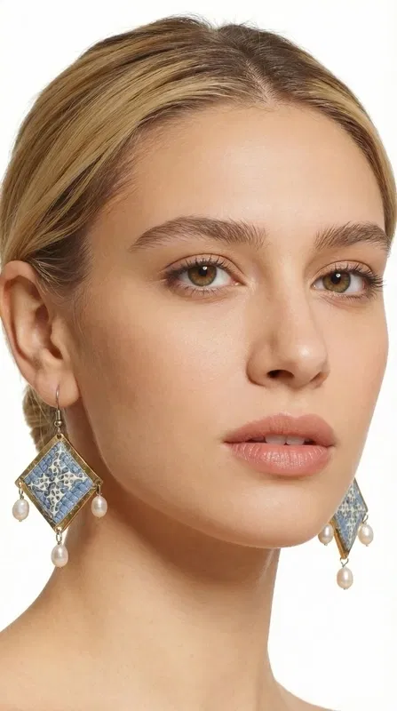 Τα statement κεντητά σκουλαρίκια σε γαλάζιο χρώμα με γεωμετρικά σχέδια από χρυσοκλωστή αποτελούν το ιδανικό χειροποίητο κόσμημα για να αναδείξετε τη μοναδικότητά σας. Αυτά τα εντυπωσιακά κρεμαστά σκουλαρίκια, σχεδιασμένα από την Ελληνίδα Σχεδιάστρια Κοσμημάτων Αικατερίνη Χαλκιαδάκη, συνδυάζουν την παραδοσιακή τέχνη του κεντήματος με μοντέρνα αισθητική.
Η γαλάζια απόχρωση σε συνδυασμό με τη χρυσοκλωστή δημιουργεί μια εκλεπτυσμένη αντίθεση που προσελκύει τα βλέμματα. Τα γεωμετρικά σχέδια προσδίδουν σύγχρονο χαρακτήρα, ενώ οι λεπτές πέρλες που κρέμονται από τη βάση των σκουλαρικιών προσθέτουν κίνηση και θηλυκότητα. Το folklore design τους τα καθιστά ιδανικά για ιδιαίτερες στιγμές, από νυφικές εμφανίσεις έως κοκτέιλ παρτυ. Ιδανικά σκουλαρίκαι για γάμους, βαπτίσεις και ιδιαίτερες εκδηλώσεις. Συντηρείστε τα με προσοχή, αποφεύγοντας την επαφή με νερό και αρώματα για μεγαλύτερη διάρκεια ζωής.