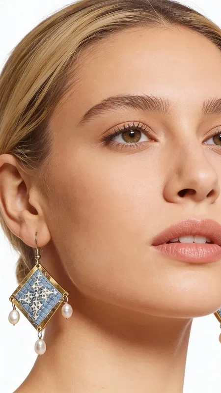 , Τα statement κεντητά σκουλαρίκια σε γαλάζιο χρώμα με γεωμετρικά σχέδια από χρυσοκλωστή αποτελούν το ιδανικό χειροποίητο κόσμημα για να αναδείξετε τη μοναδικότητά σας. Αυτά τα εντυπωσιακά κρεμαστά σκουλαρίκια, σχεδιασμένα από την Ελληνίδα Σχεδιάστρια Κοσμημάτων Αικατερίνη Χαλκιαδάκη, συνδυάζουν την παραδοσιακή τέχνη του κεντήματος με μοντέρνα αισθητική.
Η γαλάζια απόχρωση σε συνδυασμό με τη χρυσοκλωστή δημιουργεί μια εκλεπτυσμένη αντίθεση που προσελκύει τα βλέμματα. Τα γεωμετρικά σχέδια προσδίδουν σύγχρονο χαρακτήρα, ενώ οι λεπτές πέρλες που κρέμονται από τη βάση των σκουλαρικιών προσθέτουν κίνηση και θηλυκότητα. Το folklore design τους τα καθιστά ιδανικά για ιδιαίτερες στιγμές, από νυφικές εμφανίσεις έως κοκτέιλ παρτυ. Ιδανικά σκουλαρίκαι για γάμους, βαπτίσεις και ιδιαίτερες εκδηλώσεις. Συντηρείστε τα με προσοχή, αποφεύγοντας την επαφή με νερό και αρώματα για μεγαλύτερη διάρκεια ζωής.