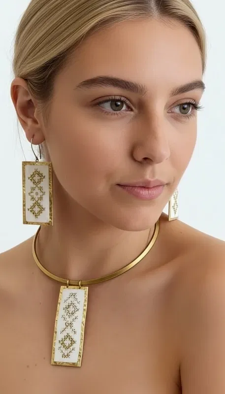 , Αυτά τα εντυπωσιακά statement σκουλαρίκια κεντητά με χρυσοκλωστή συνδυάζουν την παραδοσιακή τέχνη του κεντήματος με τη σύγχρονη αισθητική. Σχεδιασμένα από την Ελληνίδα Σχεδιάστρια Κοσμημάτων Αικατερίνη Χαλκιαδάκη, αυτά τα χειροποίητα σκουλαρίκια διακοσμούνται με γεωμετρικά μοτίβα σε λευκή βάση που δημιουργούν μια κομψή και διαχρονική εμφάνιση.
Τα κρεμαστά σκουλαρίκια χαρακτηρίζονται από τη λεπτομερή χρυσή κεντητή διακόσμηση που σχηματίζει ρομβοειδή σχέδια, προσφέροντας μια μοναδική υφή και όγκο. Η λευκή βάση δημιουργεί την τέλεια αντίθεση με τις χρυσές λεπτομέρεις, ενώ το ορθογώνιο σχήμα τους τα καθιστά ιδανικά για κάθε περίσταση.
Αυτά τα μοντέρνα κεντητά σκουλαρίκια είναι η τέλεια επιλογή για γυναίκες που αγαπούν τα εντυπωσιακά κοσμήματα με παραδοσιακά στοιχεία. Συνδυάζονται αρμονικά με κλασικά και σύγχρονα outfit, προσθέτοντας μια νότα κομψότητας και πρωτοτυπίας. Φυλάσσετε σε στεγνό μέρος και καθαρίζετε απαλά με στεγνό πανί.