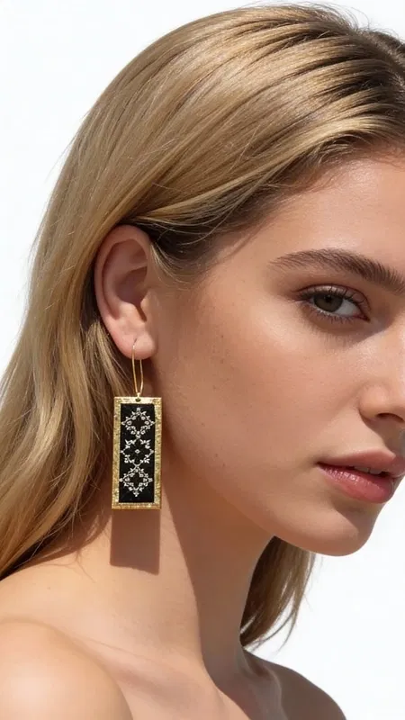 , Τα κεντητά σκουλαρίκια statement με γεωμετρικά σχέδια από χρυσοκλωστή σε μαύρο υπόβαθρο αποτελούν ένα εκπληκτικό κόσμημα που συνδυάζει παραδοσιακή τέχνη κεντήματος με μοντέρνα αισθητική. Σχεδιασμένα από την Ελληνίδα Σχεδιάστρια Κοσμημάτων Αικατερίνη Χαλκιαδάκη, αυτά τα χειροποίητα σκουλαρίκια φέρουν έντονη προσωπικότητα και ελληνικό χαρακτήρα.
Η ορθογώνια φόρμα με τα περίτεχνα γεωμετρικά μοτίβα δημιουργεί μια εντυπωσιακή οπτική αντίθεση μεταξύ του βαθιά μαύρου υποβάθρου και της χρυσής κλωστής. Κάθε σκουλαρίκι κεντιέται χειροποίητα με ιδιαίτερη προσοχή στη λεπτομέρεια, δημιουργώντας ένα μοναδικό κόσμημα που ξεχωρίζει από τα συνηθισμένα.
Αυτά τα statement σκουλαρίκια είναι ιδανικά για ειδικές στιγμές και εμφανίσεις που απαιτούν κομψότητα και στυλ. Συνδυάζονται τέλεια με μαύρα ή χρυσά ρούχα, προσφέροντας μια πινελιά ελληνικής παράδοσης σε κάθε εμφάνιση. Φροντίστε τα ήπια και αποθηκεύστε τα σε στεγνό μέρος για να διατηρήσουν τη λάμψη τους.