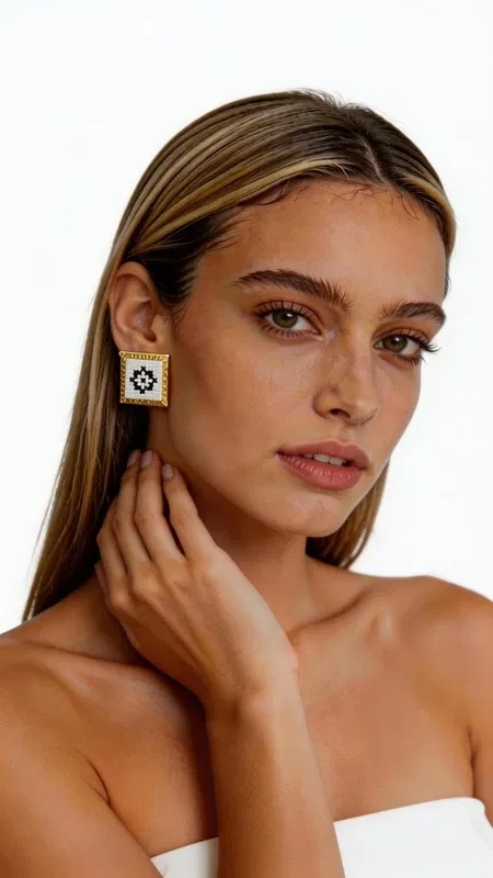 Τα κεντητά σκουλαρίκια statement με γεωμετρικά σχέδια από χρυσοκλωστή σε άσπρο αποτελούν την τέλεια επιλογή για τη γυναίκα που αναζητά εντυπωσιακά και μοντέρνα κοσμήματα. Σχεδιασμένα από την Ελληνίδα Σχεδιάστρια Κοσμημάτων Αικατερίνη Χαλκιαδάκη, συνδυάζουν την παραδοσιακή τέχνη του κεντήματος με σύγχρονη αισθητική. Κάθε σκουλαρίκι διαθέτει τετράγωνη φόρμα με εκλεπτυσμένο γεωμετρικό μοτίβο κεντημένο με χρυσοκλωστή σε λευκή βάση. Το folklore design δημιουργεί μια μοναδική αντίθεση που προσδίδει κομψότητα και χαρακτήρα σε κάθε εμφάνιση. Τα χειροποίητα σκουλαρίκια είναι ιδανικά για γάμο, ειδικές εκδηλώσεις ή ως καθημερινό statement κόσμημα. Η υψηλή ποιότητα κατασκευής και τα επιλεγμένα υλικά εγγυώνται ανθεκτικότητα και άνεση στη χρήση. Το ελαφρύ τους βάρος τα καθιστά κατάλληλα για όλη τη μέρα, ενώ το μέγεθός τους προσδίδει τη σωστή δόση glamour χωρίς υπερβολή. Υλικό: Ορείχαλκος, Ύφασμα Φροντίστε τα σκουλαρίκια σας αποφεύγοντας την επαφή με νερό και αρώματα. Φυλάσσετε τα σε στεγνό μέρος για να διατηρήσουν τη λάμψη τους.