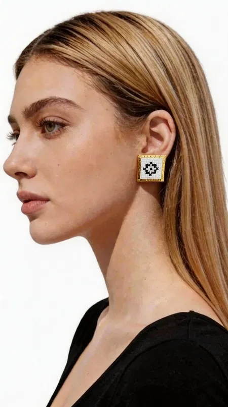 , Τα κεντητά σκουλαρίκια statement με γεωμετρικά σχέδια από χρυσοκλωστή σε άσπρο αποτελούν την τέλεια επιλογή για τη γυναίκα που αναζητά εντυπωσιακά και μοντέρνα κοσμήματα. Σχεδιασμένα από την Ελληνίδα Σχεδιάστρια Κοσμημάτων Αικατερίνη Χαλκιαδάκη, συνδυάζουν την παραδοσιακή τέχνη του κεντήματος με σύγχρονη αισθητική. Κάθε σκουλαρίκι διαθέτει τετράγωνη φόρμα με εκλεπτυσμένο γεωμετρικό μοτίβο κεντημένο με χρυσοκλωστή σε λευκή βάση. Το folklore design δημιουργεί μια μοναδική αντίθεση που προσδίδει κομψότητα και χαρακτήρα σε κάθε εμφάνιση. Τα χειροποίητα σκουλαρίκια είναι ιδανικά για γάμο, ειδικές εκδηλώσεις ή ως καθημερινό statement κόσμημα. Η υψηλή ποιότητα κατασκευής και τα επιλεγμένα υλικά εγγυώνται ανθεκτικότητα και άνεση στη χρήση. Το ελαφρύ τους βάρος τα καθιστά κατάλληλα για όλη τη μέρα, ενώ το μέγεθός τους προσδίδει τη σωστή δόση glamour χωρίς υπερβολή. Υλικό: Ορείχαλκος, Ύφασμα Φροντίστε τα σκουλαρίκια σας αποφεύγοντας την επαφή με νερό και αρώματα. Φυλάσσετε τα σε στεγνό μέρος για να διατηρήσουν τη λάμψη τους.