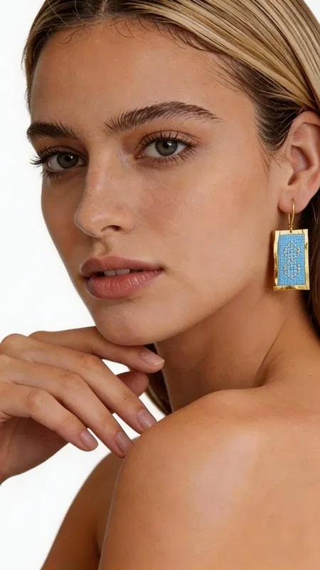 Τα statement κεντητά σκουλαρίκια σε γαλάζιο χρώμα αποτελούν την τέλεια επιλογή για γυναίκες που θέλουν να ξεχωρίσουν με στυλ και κομψότητα. Σχεδιασμένα από την Ελληνίδα Σχεδιάστρια Κοσμημάτων Αικατερίνη Χαλκιαδάκη, αυτά τα εντυπωσιακά χειροποίητα κοσμήματα συνδυάζουν τη μοντέρνα αισθητική με την παραδοσιακή τεχνική του κεντήματος. Η χρυσοκλωστή δημιουργεί γεωμετρικά σχέδια που πλαισιώνουν υπέροχα το γαλάζιο χρώμα, δίνοντας μια μοναδική λάμψη και κίνηση. Το ορθογώνιο σχήμα των σκουλαρικιών προσφέρει σύγχρονη αισθητική, ενώ η κεντητή υφή προσθέτει βάθος και χαρακτήρα. Είναι ιδανικά για ειδικές περιστάσεις, γάμους, αλλά και για να προσδώσουν εκλεπτυσμένη νότα στην καθημερινή εμφάνιση. Υλικό: Ορείχαλκος, Ύφασμα Φροντίστε να τα φυλάσσετε σε στεγνό μέρος και αποφύγετε την επαφή με υγρασία για να διατηρήσουν τη λάμψη τους. Συνδυάστε τα με απλά ρούχα για να αναδείξετε την ομορφιά τους.