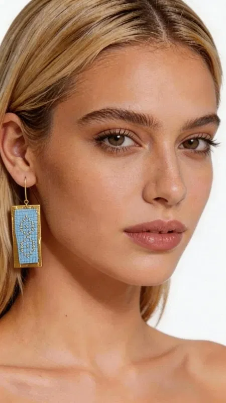 , Τα statement κεντητά σκουλαρίκια σε γαλάζιο χρώμα αποτελούν την τέλεια επιλογή για γυναίκες που θέλουν να ξεχωρίσουν με στυλ και κομψότητα. Σχεδιασμένα από την Ελληνίδα Σχεδιάστρια Κοσμημάτων Αικατερίνη Χαλκιαδάκη, αυτά τα εντυπωσιακά χειροποίητα κοσμήματα συνδυάζουν τη μοντέρνα αισθητική με την παραδοσιακή τεχνική του κεντήματος. Η χρυσοκλωστή δημιουργεί γεωμετρικά σχέδια που πλαισιώνουν υπέροχα το γαλάζιο χρώμα, δίνοντας μια μοναδική λάμψη και κίνηση. Το ορθογώνιο σχήμα των σκουλαρικιών προσφέρει σύγχρονη αισθητική, ενώ η κεντητή υφή προσθέτει βάθος και χαρακτήρα. Είναι ιδανικά για ειδικές περιστάσεις, γάμους, αλλά και για να προσδώσουν εκλεπτυσμένη νότα στην καθημερινή εμφάνιση. Υλικό: Ορείχαλκος, Ύφασμα Φροντίστε να τα φυλάσσετε σε στεγνό μέρος και αποφύγετε την επαφή με υγρασία για να διατηρήσουν τη λάμψη τους. Συνδυάστε τα με απλά ρούχα για να αναδείξετε την ομορφιά τους.