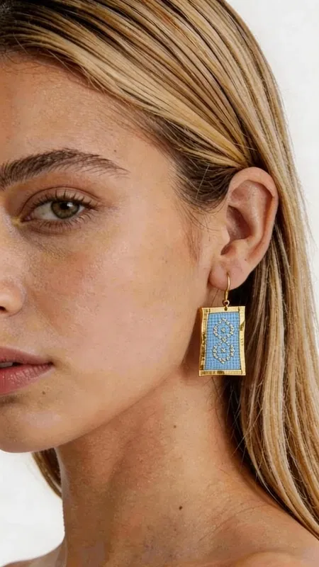 , Τα statement κεντητά σκουλαρίκια σε γαλάζιο χρώμα αποτελούν την τέλεια επιλογή για γυναίκες που θέλουν να ξεχωρίσουν με στυλ και κομψότητα. Σχεδιασμένα από την Ελληνίδα Σχεδιάστρια Κοσμημάτων Αικατερίνη Χαλκιαδάκη, αυτά τα εντυπωσιακά χειροποίητα κοσμήματα συνδυάζουν τη μοντέρνα αισθητική με την παραδοσιακή τεχνική του κεντήματος. Η χρυσοκλωστή δημιουργεί γεωμετρικά σχέδια που πλαισιώνουν υπέροχα το γαλάζιο χρώμα, δίνοντας μια μοναδική λάμψη και κίνηση. Το ορθογώνιο σχήμα των σκουλαρικιών προσφέρει σύγχρονη αισθητική, ενώ η κεντητή υφή προσθέτει βάθος και χαρακτήρα. Είναι ιδανικά για ειδικές περιστάσεις, γάμους, αλλά και για να προσδώσουν εκλεπτυσμένη νότα στην καθημερινή εμφάνιση. Υλικό: Ορείχαλκος, Ύφασμα Φροντίστε να τα φυλάσσετε σε στεγνό μέρος και αποφύγετε την επαφή με υγρασία για να διατηρήσουν τη λάμψη τους. Συνδυάστε τα με απλά ρούχα για να αναδείξετε την ομορφιά τους.