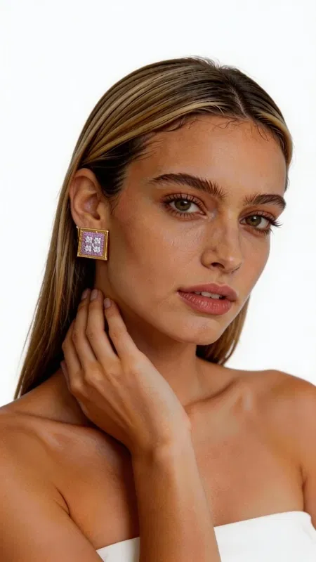 , Τα κεντητά statement σκουλαρίκια με γεωμετρικά σχέδια σε λιλά απόχρωση θα γίνουν το αγαπημένο σας αξεσουάρ για κάθε ιδιαίτερη περίσταση. Σχεδιασμένα από την Ελληνίδα Σχεδιάστρια Κοσμημάτων Αικατερίνη Χαλκιαδάκη, αυτά τα εντυπωσιακά χειροποίητα σκουλαρίκια συνδυάζουν την παραδοσιακή τέχνη του κεντήματος με σύγχρονο design. Η τετράγωνη φόρμα με τα περίτεχνα γεωμετρικά μοτίβα δημιουργεί ένα μοναδικό οπτικό αποτέλεσμα, ενώ η χρυσοκλωστή προσδίδει λάμψη και κομψότητα. Το ρομαντικό λιλά χρώμα αναδεικνύει την θηλυκότητα και προσφέρει ευελιξία στον συνδυασμό με διάφορα outfits. Αυτά τα μοντέρνα κεντητά σκουλαρίκια είναι ιδανικά για γάμους, βραδινές εξόδους αλλά και για να αναβαθμίσετε την καθημερινή σας εμφάνιση. Η χειροποίητη κατασκευή εγγυάται τη μοναδικότητα και την ποιότητα κάθε κομματιού. Υλικό: Ορείχαλκος, Ύφασμα **Φροντίδα:** Φυλάσσετε τα σκουλαρίκια σε στεγνό μέρος και αποφεύγετε την επαφή με νερό και καλλυντικά για να διατηρήσετε τη λάμψη της χρυσοκλωστής.