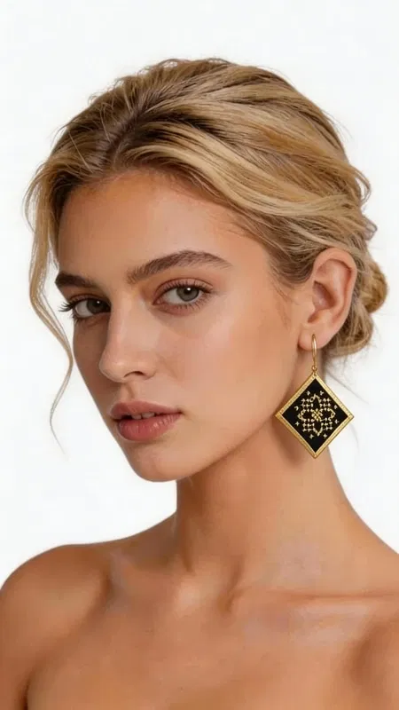 , Τα statement κεντητά σκουλαρίκια με γεωμετρικά σχέδια από χρυσοκλωστή σε μαύρο φόντο είναι η τέλεια επιλογή για κάθε γυναίκα που αναζητά εντυπωσιακά και μοναδικά κοσμήματα. Σχεδιασμένα από την Ελληνίδα Σχεδιάστρια Κοσμημάτων Αικατερίνη Χαλκιαδάκη, αυτά τα χειροποίητα σκουλαρίκια συνδυάζουν την παραδοσιακή τέχνη του κεντήματος με σύγχρονο γεωμετρικό design. Κάθε σκουλαρίκι διαθέτει τετραγωνικό σχήμα με περίτεχνα χρυσά κεντήματα που σχηματίζουν εκλεπτυσμένα γεωμετρικά μοτίβα πάνω σε μαύρο υπόστρωμα. Η χρυσοκλωστή δημιουργεί υπέροχες αντανακλάσεις φωτός, προσδίδοντας λάμψη και κομψότητα σε κάθε κίνηση. Τα κρεμαστά σκουλαρίκια έχουν ιδανικό μέγεθος για να κάνουν statement χωρίς να είναι υπερβολικά. Αυτά τα μοντέρνα σκουλαρίκια είναι ιδανικά για ιδιαίτερες περιστάσεις, γάμους, βραδινές εξόδους αλλά και για να προσδώσουν μια πινελιά κομψότητας στην καθημερινότητά σας. Συνδυάζονται άψογα με μαύρα, χρυσά ή έντονα χρώματα. Υλικό: Ορείχαλκος, Ύφασμα Φροντίστε τα κεντητά σκουλαρίκια σας αποθηκεύοντάς τα σε στεγνό μέρος και αποφεύγοντας την επαφή με αρώματα και καλλυντικά.