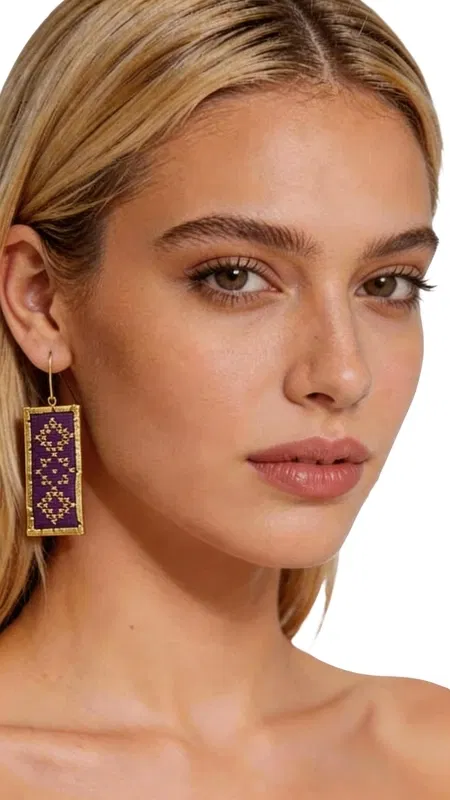 Τα statement κεντητά σκουλαρίκια με γεωμετρικά σχέδια από χρυσοκλωστή σε εντυπωσιακό μπορντό χρώμα είναι το τέλειο αξεσουάρ για κάθε γυναίκα που θέλει να ξεχωρίσει. Σχεδιασμένα από την Ελληνίδα Σχεδιάστρια Κοσμημάτων Αικατερίνη Χαλκιαδάκη, αυτά τα χειροποίητα σκουλαρίκια συνδυάζουν την παραδοσιακή τέχνη του κεντήματος με μοντέρνο design. Η πολυτελής χρυσοκλωστή δημιουργεί εκλεπτυσμένα γεωμετρικά μοτίβα που αναδεικνύουν τη μαεστρία της ελληνικής χειροτεχνίας. Το βαθύ μπορντό χρώμα προσφέρει κομψότητα και στυλ, ενώ το ορθογώνιο σχήμα των σκουλαρικιών τους κάνει ιδανικούς για επίσημες εκδηλώσεις, γάμους ή βραδινές εξόδους. Αυτά τα εντυπωσιακά κρεμαστά σκουλαρίκια είναι κατάλληλα για γυναίκες που αγαπούν τα πρωτότυπα χειροποίητα κοσμήματα με ιδιαίτερη αισθητική. Συνδυάζονται τέλεια με μονόχρωμα outfits και δίνουν μια boho πινελιά στο look σας. Υλικό: Ορείχαλκος, Ύφασμα Για τη διατήρηση της ομορφιάς τους, φυλάσσετε τα σκουλαρίκια σε στεγνό μέρος και αποφεύγετε την επαφή με νερό και χημικά προϊόντα.