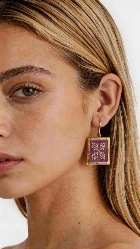 , Κεντητά statement σκουλαρίκια που συνδυάζουν την παραδοσιακή τέχνη του κεντήματος με σύγχρονο γεωμετρικό design. Αυτά τα εντυπωσιακά σκουλαρίκια σε έντονο μπορντό χρώμα, σχεδιασμένα από την Ελληνίδα Σχεδιάστρια Κοσμημάτων Αικατερίνη Χαλκιαδάκη, προσφέρουν μια μοναδική αισθητική που ξεχωρίζει. Η χρυσοκλωστή δημιουργεί περίπλοκα γεωμετρικά μοτίβα που αναδεικνύουν το folklore design, ενώ το τετράγωνο σχήμα προσδίδει μοντέρνα κομψότητα. Κάθε κέντημα είναι χειροποίητο με ιδιαίτερη προσοχή στη λεπτομέρεια, δημιουργώντας ένα κόσμημα που συνδυάζει τέχνη και στυλ. Η μπορντό απόχρωση είναι ιδανική για να προσθέσει χρώμα και χαρακτήρα σε κάθε σας εμφάνιση. Τα σκουλαρίκια αυτά είναι ιδανικά για ειδικές περιστάσεις, από βραδινές εξόδους έως γαμήλιες εκδηλώσεις, αλλά και για να αναβαθμίσουν την καθημερινή σας εμφάνιση. Συνδυάζονται τέλεια με μονόχρωμα outfits και προσθέτουν έναν εντυπωσιακό ethnic χαρακτήρα. Υλικό: Ορείχαλκος, Ύφασμα Φροντίδα: Αποθηκεύστε σε στεγνό μέρος και αποφύγετε την επαφή με υγρασία για να διατηρήσετε τη λάμψη της χρυσοκλωστής.