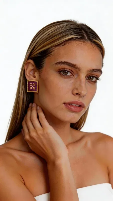 Τα statement κεντητά σκουλαρίκια με γεωμετρικά σχέδια από χρυσοκλωστή σε υπέροχο μπορντό χρώμα προσδίδουν μια μοναδική πινελιά κομψότητας σε κάθε σας εμφάνιση. Σχεδιασμένα από την Ελληνίδα Σχεδιάστρια Κοσμημάτων Αικατερίνη Χαλκιαδάκη, αυτά τα εντυπωσιακά χειροποίητα σκουλαρίκια συνδυάζουν την παραδοσιακή τέχνη του κεντήματος με σύγχρονο design. Κάθε σκουλαρίκι δημιουργείται με ιδιαίτερη προσοχή στη λεπτομέρεια, χρησιμοποιώντας χρυσοκλωστή που σχηματίζει γεωμετρικά μοτίβα σε βαθύ μπορντό φόντο. Η τετραγωνική φόρμα με χρυσό περίγραμμα προσφέρει μια σύγχρονη ερμηνεία του κλασικού κεντήματος, ιδανικά για γυναίκες που αγαπούν τα statement κοσμήματα. Αυτά τα μοναδικά σκουλαρίκια είναι τέλεια για ιδιαίτερες στιγμές όπως γάμους, βραδινές εξόδους ή επαγγελματικά events. Συνδυάζονται υπέροχα με μονόχρωμα outfits, προσδίδοντας χρώμα και κομψότητα. Υλικό: Ορείχαλκος, Ύφασμα Φροντίδα: Φυλάσσετε σε στεγνό μέρος και αποφεύγετε την επαφή με νερό και χημικά προϊόντα για τη διατήρηση των χρωμάτων.